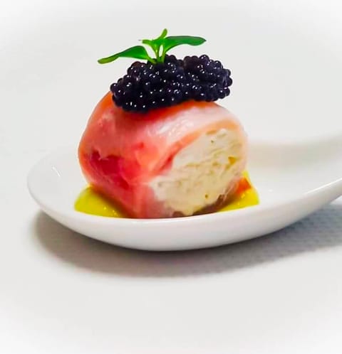 Bocconcino di crudo con mousse e caviale su crema agli agrumi, in cucchiaio di porcellana